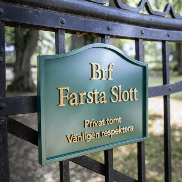 Grindskylt i grönlackerad gjuten aluminium med text i guldtitanlegerat rostfritt stål
