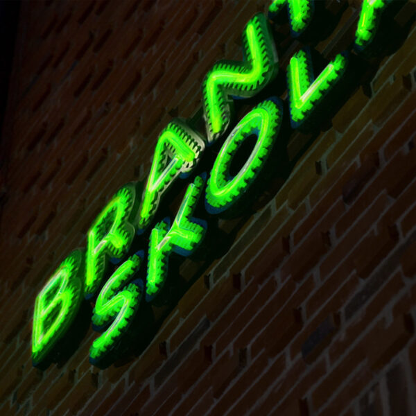 Fasadskylt med individuella profilbokstäver i grön lackerad aluminium, centrerade konturfrästa toppbokstäver och grön LED-neon i rundglansig akryl - Bild 4