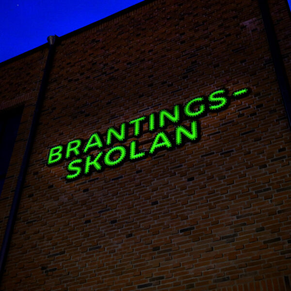 Fasadskylt med individuella profilbokstäver i grön lackerad aluminium, centrerade konturfrästa toppbokstäver och grön LED-neon i rundglansig akryl - Bild 3