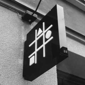 Flaggskylt i svart akryl med LED-belyst upphöjd logotyp