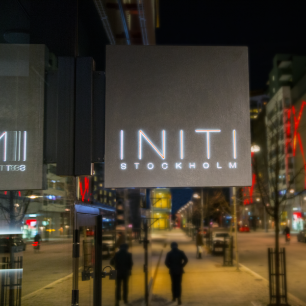 Flaggskylt i patinerad betong med upphöjd LED-belyst logotyptext och dekor