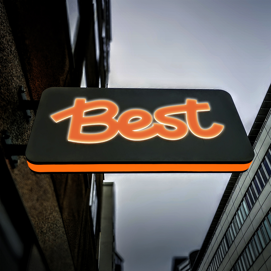 Flaggskylt med orange LED-belyst midja och upphöjda vitbelysta profilbokstäver med translucent orange dekor – tydlig och färgstark ljusskylt