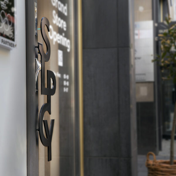Dörrskylt i form av handtag i svartlackerat rostfritt stål – metallformad logotyp som funktionellt dörrhandtag för butikens entré - Bild 6