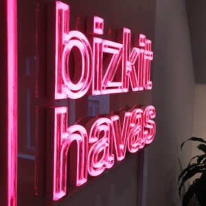 Receptionsskylt med LED-neon profilbokstäver i transparent akryl – RGBW-appstyrd belysning och lackerad sockel för väggmontage