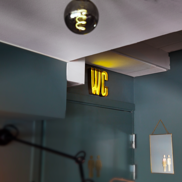 Receptionsskylt i koppartitanlegerat rostfritt stål med skärmningskant och gul LED-neon i mitten av bokstavskroppen - Bild 5