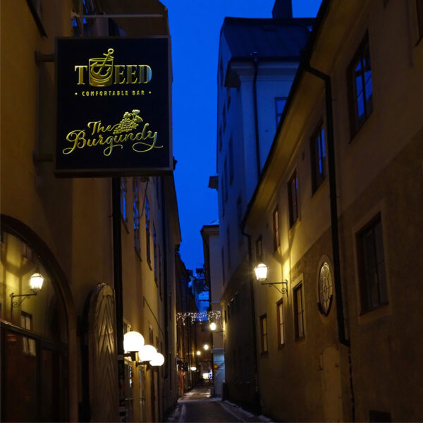 Flaggskylt i svartlackerad aluminium med inifrån LED-belysning, dekaperad logotyp på båda sidor och toppad med gulddekor - Bild 3