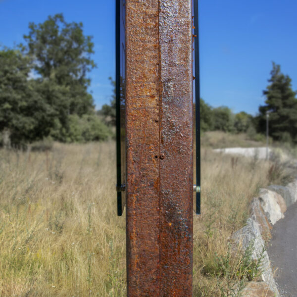 Pylonskylt i rostad corten med distansmonterad glasskylt i optiwhite