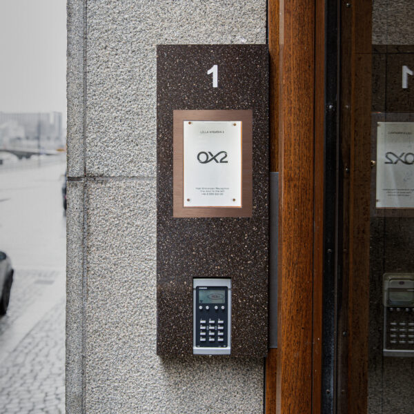 Fastighetsskylt som infoskåp i Corian med glasdörr och borstade kopparkantlister – porttelefoninkapsling med appstyrd belysning och lås - Bild 5