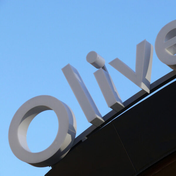 Fasadskylt i välvd form i lackerad aluminium med framifrån LED-belysta individuella profilbokstäver monterad ovanpå entrétak - Bild 2