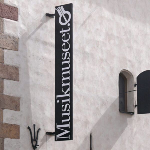 Musik Museet Flaggskylt i Svartlackerad Aluminium med Vit Vinyldekor