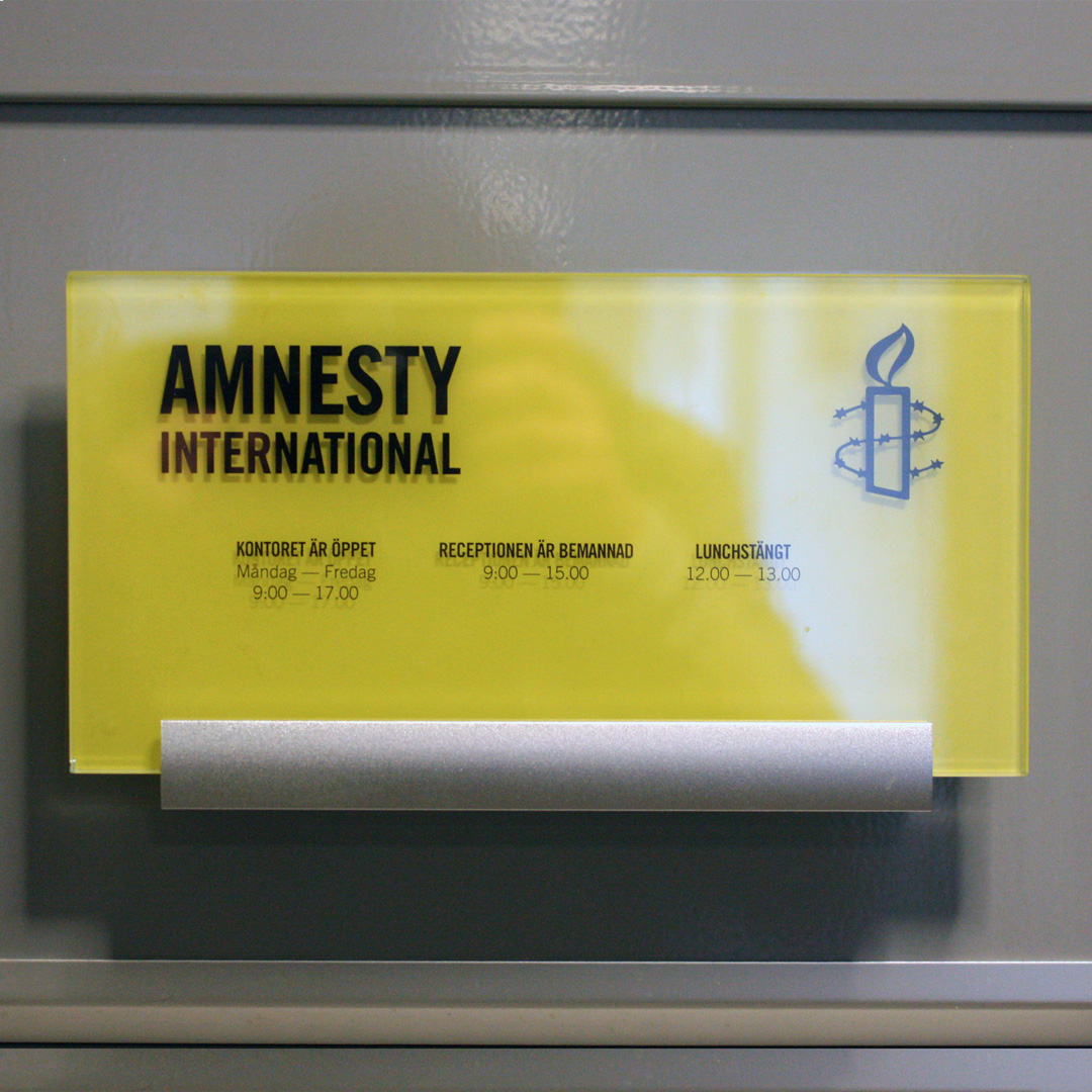 Dörrskylt i dubbel akryl med rostfria detaljer för Amnesty