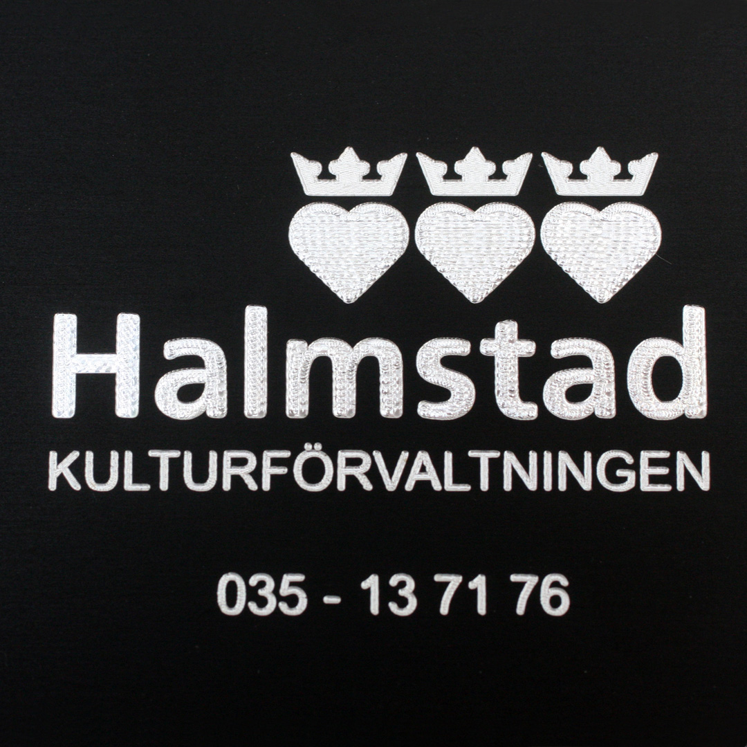 Taktilskylt i svarteloxerad aluminium med blindskrift