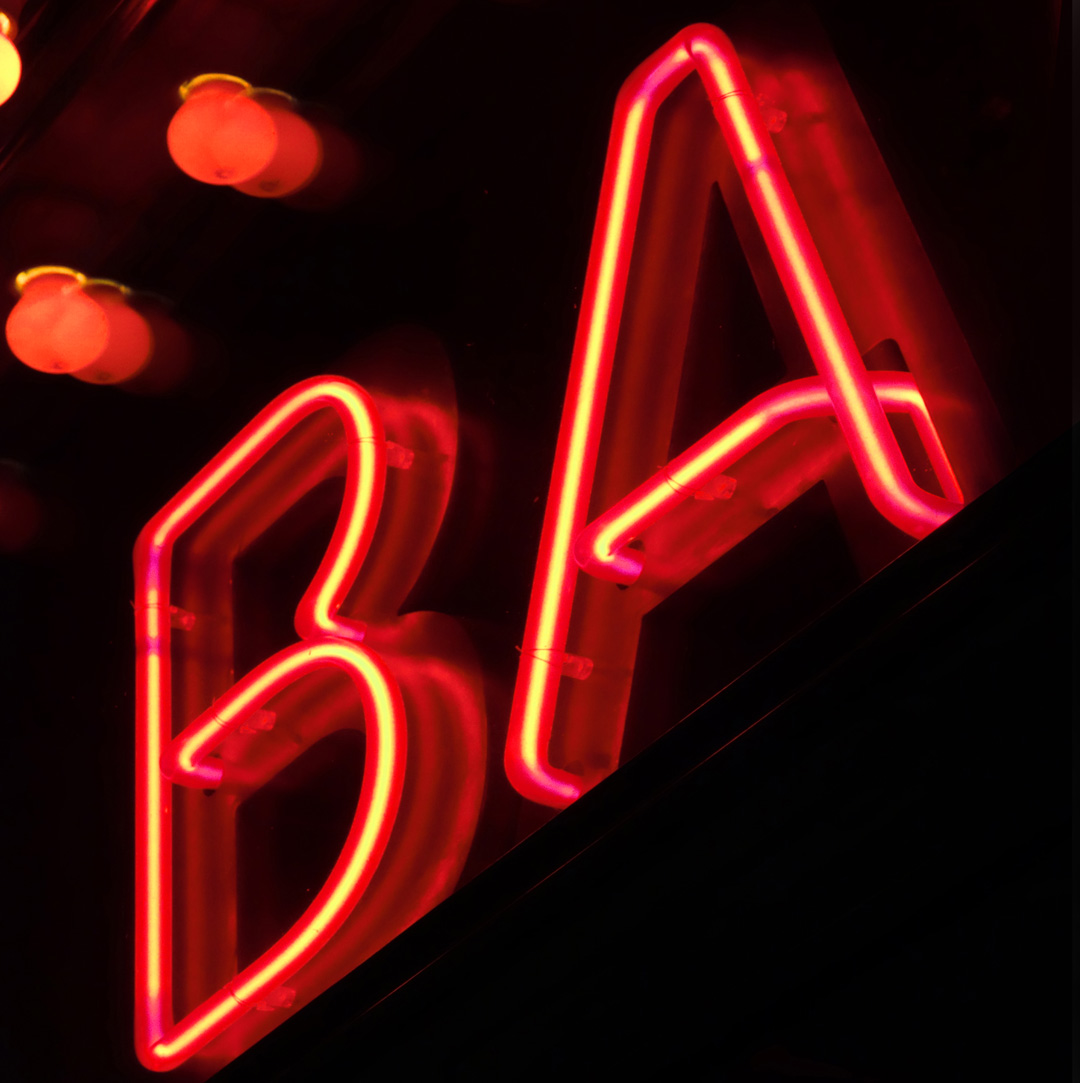Fasadskylt med patinerad koppar & röd neon i klarglasbokstäver