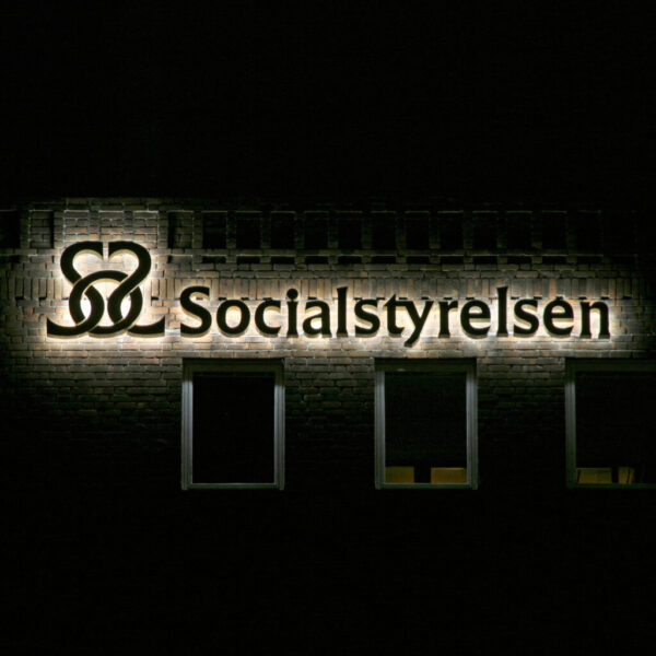 Fasadskylt i guldlackerad aluminium med individuella profilbokstäver och LED-bakbelysning – distansmonterad för halo-effekt