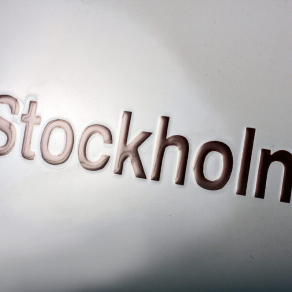 Konvex emaljskylt i vitt med brun och svart text