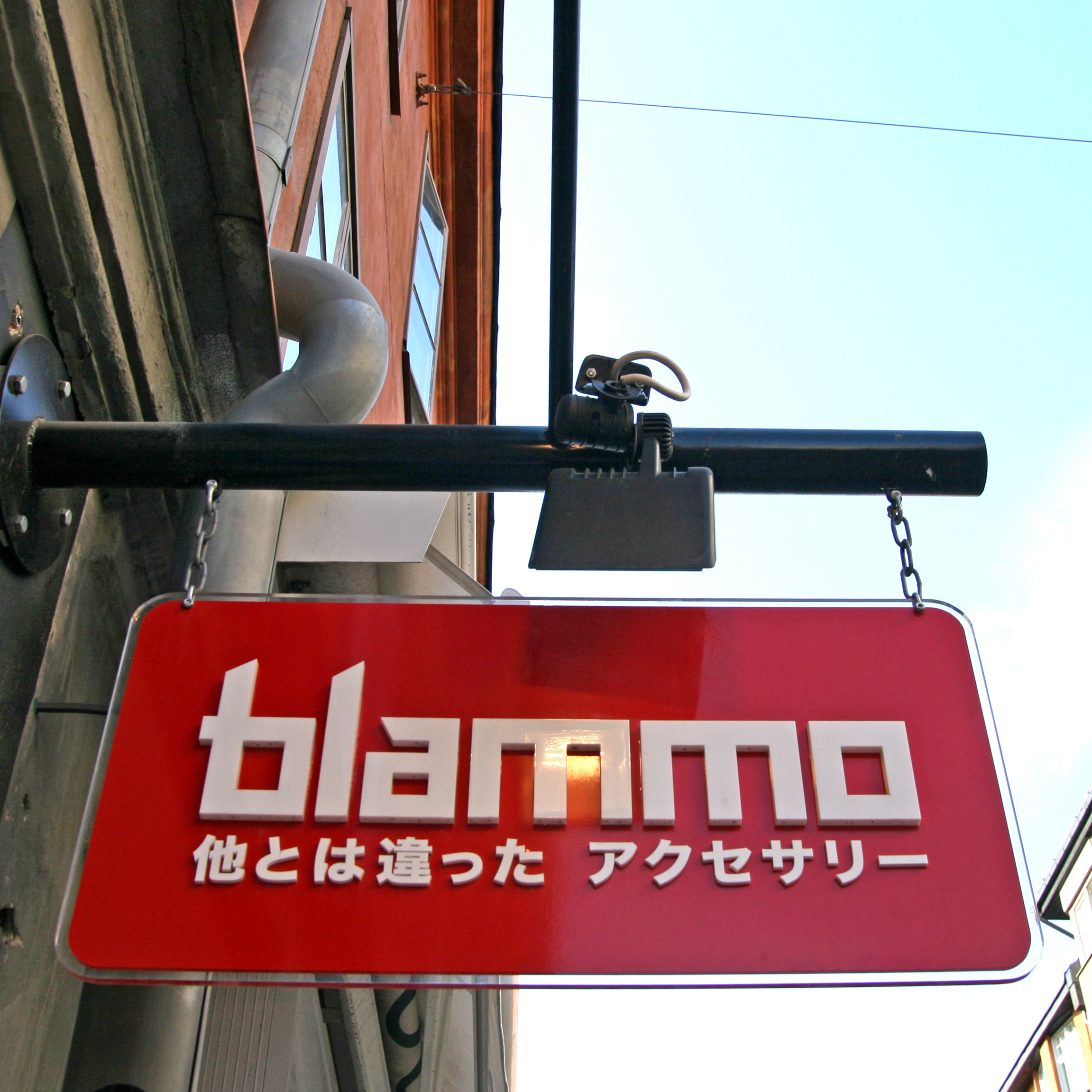 Smidesskylt Blommo med transparent akryl och vit logotyp