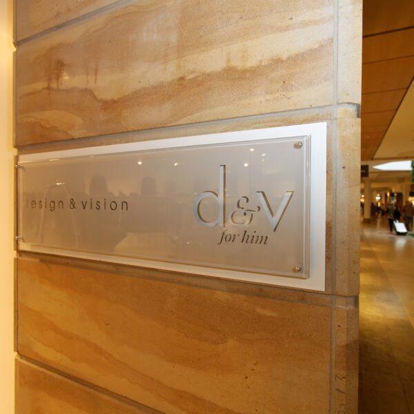 Design & Vision - D&V for him Fasadskylt i transparent akryl på aluminiumplåt