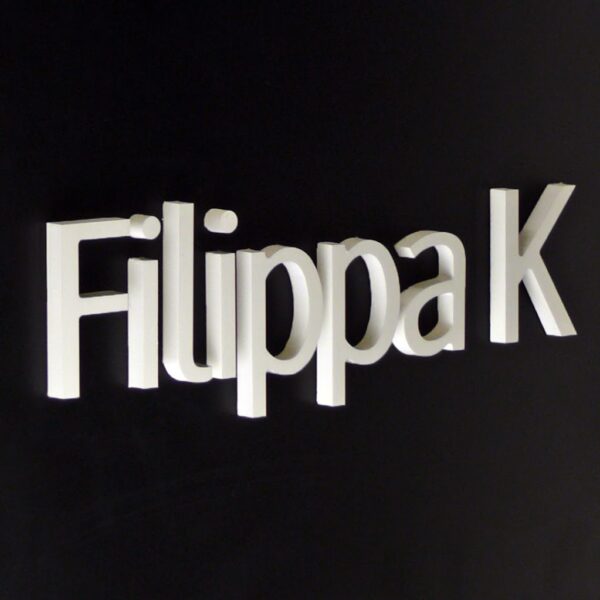 Flaggskylt Filippa K – svart plåtskylt med vit akryl logotyp