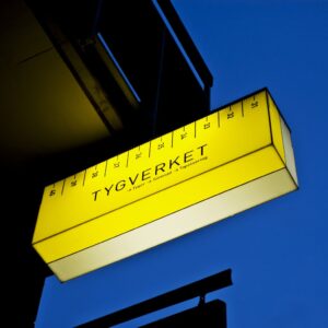 Tygverket flaggskylt med akrylbox – dubbelsidig fasadskylt